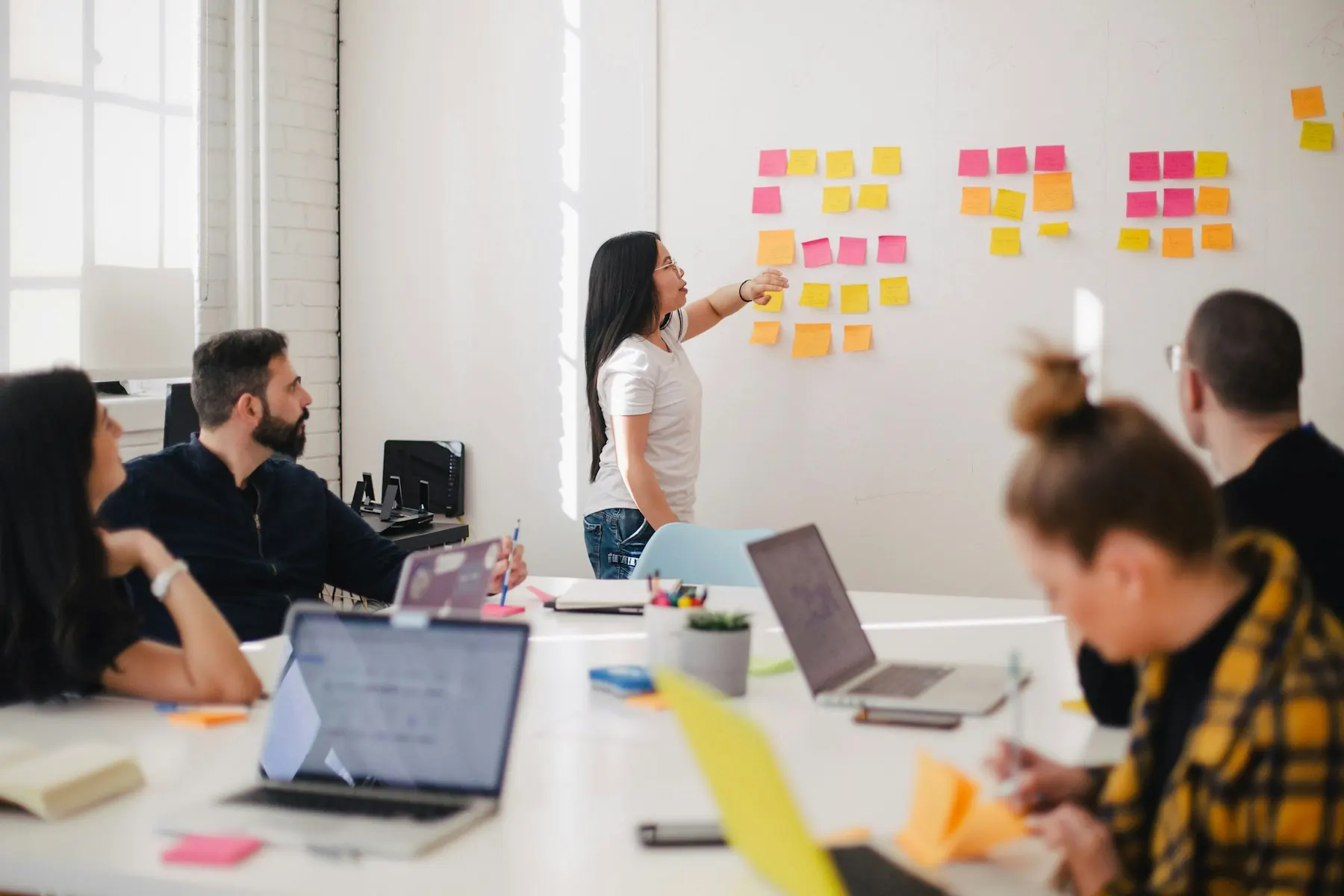 Team workshop in front of a board of sticky notes